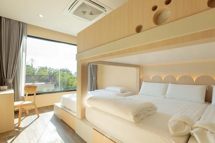 ห้องนอนโทนไม้อ่อนกว้างขวางที่ Jaidee Pool Villa รับครอบครัวใหญ่
